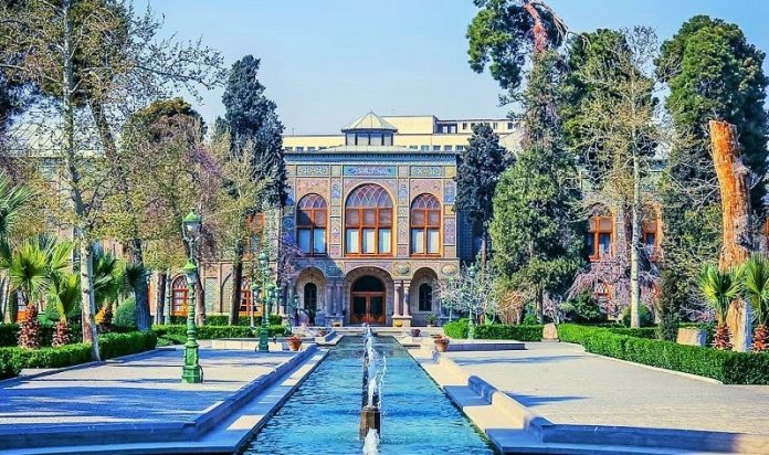 کاخ گلستان تهران یکی از آثار جهانی ایران کاخ گلستان تهران یکی از آثار جهانی ایران در فهرست میراث یونسکو می باشد . این کاخ به لطف معماری و تزئینات خارق العاده ، محیطی ایده آل برای عکاسی و ثبت لحظات خوشِ زندگی است . علاوه بر تمامی این ها ، وقوع رُخداد تاریخی مهم در این فضا ، آن را به جلوه ای زنده از تاریخ ایران تبدیل نموده است . این بنا در بافت قدیمی پایتخت جای خوش کرده است و شما می توانید ، به راحتی و با استفاده از وسایل حمل و نقل عمومی بدان دسترسی پیدا کنید . اگر که برای اوّلین بار به این مکان سیر و سفر می کنید ، قطعاً از زیبایی ها و شکوه آن محصور خواهید شد . معرفی بیشتر کاخ گلستان کاخ گلستان تهران دربرگیرنده مجموعه ای از بناهای تاریخی در پایتخت است ، که طی بازه زمانی مختلف ساخته شده است . این کاخ از نظر معماری و ارزش آثار هنری و تاریخیِ خود ، یکی از قابل توجه ترین بناهای تاریخی کشور می باشد . این کاخ از قسمت های متنوعی چون ؛ ایوان تخت مرمر ، تالار آینه ، تالار سلام ، خلوت کریمخانی ، تالار سفره خانه ، تالار برلیان ، کاخ ابیض ، کاخ شمس العماره ایجاد شده است . در این مجموعه تخت مرمر و خلوت کریمخانی متعلق به دوران کریم خان زند بوده و قدیمی ترین بنای کاخ گلستان تهران محسوب می شود . مجموعه فرهنگی و تاریخی این کاخ ، به غیر از ساختمان های نام برده شده ، از بخش های گوناگونی چون ؛ کتابخانه نسخ خطی ، مرکز اسناد تصویری ، کتابخانه چاپی ، دفتر فنی ، امور بین‌الملل ، واحد دفتر حقوقی ، واحد کودک و نوجوان ، امور معرفی و ... تشکیل شده است . مساحت کاخ گلستان چقدر است ؟ کاخ گلستان تهران از جمله مشهورترین جاهای دیدنی استان تهران است ، که قدمت آن به دهه ها پیش از دوران قاجار بازمی‌گردد . در واقع این کاخ بیشتر از 440 سال تاریخ را در دِل خود جای داده است . هم اکنون مساحت این کاخ بسیار زیبا نزدیک به ، پنج هکتار است . فضایی که جایگاهی برای حضور پادشاهان ایرانی چون ؛ ناصرالدین شاه ، مظفرالدین شاه ، احمد شاه قاجار و ... بوده است . کاخ گلستان دقیقاً کجاست ؟ این کاخ در استان تهران ، خیابان پانزده خرداد ، میدان ارگ جای گرفته است . بهره گیری از مترو ، بهترین مسیر دسترسی به کاخ گلستان می باشد ، که برای این منظور شما باید در ایستگاه مترو پانزده خرداد « در خط یک » پیاده بشوید . پس از خروج از مترو به سمت شرق حرکت کنید ، تا تقریباً بعد از پنج دقیقه پیاده روی به میدان پانزده خرداد رسید ‌. شما باید از طریق خیابان داور به ضلع شمالی این میدان روید ، که ورودی کاخ گلستان تهران دقیقاً همانجا قرار دارد . درباره معماری کاخ گلستان این کاخ از یک مجموعه تاریخی شکل گرفته است ، که دربرگیرنده چندین کاخ و تالار سلطنتی درون یک باغ می باشد . معماری این مجموعه با معماری ایرانی رقم خورده و سپس مراودات تجاری ، سیاسی و فرهنگی با کشورهای اروپایی به ایجاد تحولاتی مبنی بر معماری نئوکلاسیک اروپا گردید . به همین خاطر است ، که ما در کاخ گلستان تهران شاهد تلفیق معماری اروپایی و ایرانی با یک‌دیگر هستیم ! شما می توانید ، یکی از بهترین نمونه های کاشی کاری را در این کاخ ببینید ! این کاشی کاری ها با مضامین اساطیری ، شکار و شکارگاه ، بزم ، رزم و نبرد ، عاشقانه ، مذهبی ، حکومتی و ... می باشند . در کاشی کاری های موجود تأثیر وسعت ارتباط با دنیای غرب و حمایت از هنر کاملاً مشخص است . این تنها نمای بیرونی ساختمان کاخ نمی باشد ، که کاشی کاری چَشم نواز نظر شما را به خود جلب می کند ، تنها کافیست وارد بنا شوید . آینه کاری های موجود قطعاً هوش از سَر شما خواهد برد ! به خصوص در تالار آینه که تزئینات آن بیش از پنج سال به طول انجامید . تزئینات طلاکاری برروی سنگ نیز قسمت دیگری از جذابیت و زیبایی شمس العماره و تخت مرمر را ایجاد می کند ، که در دوران حکومت قاجار رایج بوده است . در این تزئینات از کاخ گلستان تهران از ورق فلزی استفاده کرده اند ، که مهارت و ذوق هنرمندان طلاکوب آن زمان را به رُخ می کشد . بخش های مختلف کاخ گلستان ما در این قسمت از مطلب خود به چند بخش از زیباترین قسمت های کاخ گلستان اشاره خواهیم کرد . قطعاً تمامی نقاط این کاخ زیبا بوده و غیرقابل چَشم پوشی است ! امّا مطالب بسیار بوده و فرصت ما برای معرفی کم است ! 1. شمس العماره شاید که بتوانیم ، گل مجلس کاخ گلستان تهران را شمس العماره معرفی کنیم ! بنایی بلندبالا که از مهم ترین جاذبه های آن محسوب می شود و در روزگارانی نماد تهران بوده است . ناصرالدین شاه در سفرهای اروپایی خود ، علاقه بسیاری به آسمان خراش های آن ها پیدا کرد . به همین دلیل دستور ساخت شمس العماره را صادر کرد . او می خواست ، با زنان خود به مرتفع ترین نقطه رفته و چَشم انداز پایتخت و اطراف آن را تماشا کند . این بنا در پنج طبقه و طی سالِ 1284 ساخته شد ، که با برخورداری از ارتفاع 35 متر بلندترین ساختمان زمانِ خود محسوب می شد . برای نخستین بار در ساخت شمس العماره از فلز استفاده کردند ، که تحول عظیمی در ساختمان سازی ایران بود . علاوه بر نمای زیبا و خیره کننده شمس العماره ، تزئینات داخلی آن از آیینه کاری تا گچ بری موجب شگفتی هر تماشاگری می شود . 2. ایوان تخت مرمر ایوان تخت مرمر ، قدیمی ترین بنای تاریخی کاخ گلستان تهران از زمانِ کریمخان زند بوده ، که با تزئینات بسیار زیبای گچ بری ، سنگ تراشی ، آیینه کاری ، خاتم کاری همگام گردیده است . تماشایی ترین قسمت ایوان ، تخت مرمری می باشد ، که به دستور فتحعلی شاه طراحی و ساخته شد . وی در سالِ 1221 هجری قمری به سنگ تراشان اصفهانی دستور ساخت تختی از سنگ مرمر زرد یزد را صادر کرد ، که دربرگیرنده 65 قطعه مرمر بزرگ و کوچک بود . طراحی تخت به حالتی است ، که تخت حضرت سلیمان را در ذهن تداعی می نماید . این تخت برروی دوش سه دیو و شش فرشته یا انسان قرار گرفته است . علاوه بر تمامی این ها یک اژدها و دو شیر ، بیت هایی از ملک الشعراء در ستایش فتحعلی شاه برروی تخت مرمر نقش بسته است . 3. محوطه کاخ گلستان علاوه بر تمامی بناهایی که در کاخ گلستان تهران جلوه گری می کند ، تعداد بسیاری درخت و استخر نیز در دور و اطراف این سازه ها دیده می شود . این فضاها برای قدم زدن و عکاسی یکی از بهترین ها محسوب می شود . به عبارتی کاشی کاری های رنگارنگ و زیبای هریک از ساختمان ها ارزش گشت و گذار در محوطه کاخ گلستان را دارد . 4. تالار سلام تالار سلام در قسمت شمالی کاخ گلستان قرار دارد و از همان ابتدا به منظور ایجاد موزه شکل گرفت . سفرهای به همین دلیل ساختمان های قدیمی این قسمت از باغ تخریب شد و این موزه زیبا ساخته شد . پس نخستین موزه ایران در کاخ گلستان تهران شکل گرفت . عملیات ساخت بنای این تالار و دیگر قسمت ها در سال 1293 هجری قمری به اتمام رسید . ولی روند چیدمان و نصب تابلوها و کامل شدنِ دکوراسیون تا سال 1296 هجری قمری ادامه پیدا کرد . از آنجای که در این مکان ، مراسم سلام اجراء می شد ، به تالار سلام شهرت پیدا کرد . حال در ادامه به علت تاج گذاری شاهان پهلوی ، به عنوان تالار تاج گذاری معرفی شد ! 5. موزه مخصوص موزه مخصوص یک قسمت از حوضخانه تالار سلام می باشد ، که اشیاء گرانبهاء و زینتی باقی مانده از دوران قاجار در این قسمت از کاخ گلستان تهران نگهداری می شود . قسمتی از آن ها در گذشته در اتاق موزه ناصرالدین شاه نگهداری می شده که از دوره های گذشته به قاجارها رسیده بوده است . گاهاً هم هدیه ای از دیگر پادشاهان و هنرمندان هم عصر آن ها محسوب می شد ، که به واسطه ی خود این پادشاهان تهیه شده بود . 6. تالار آیینه تالار آینه یکی دیگر از تالارهای دیگر واقع در کاخ گلستان تهران است . تحفه سفرهای ناصرالدین شاه به اروپا این بود ، که پس از یکی از سفرهای خود ، خواهان برپایی یک موزه زیبا ، به باشکوهی موزه‌های اروپا در ارگ شد . کامل شدن ، تالار آیینه پنج سال به طول انجامید . نکته جذاب این نقاشی گستره تالار است ، که در مقایسه با تالار واقعی بسیار وسیع تر به نظر می آید . همین مسائل هنر نقاش در عظمت بخشی به تالار را به نمایش می گذارد . سخن آخر دوستان عزیز ما در این قسمت از مطلب آسمان هوم به کاخ گلستان تهران پرداختیم . امیدواریم ، که با مطالعه این بخش به خوبی درک کرده باشید ، که کاخ گلستان در کجا واقع شده و چه جذابیت هایی دارد . قطعاً شما از سیر و سفر به سمت این مجموعه نهایت لذّت را خواهید برد .